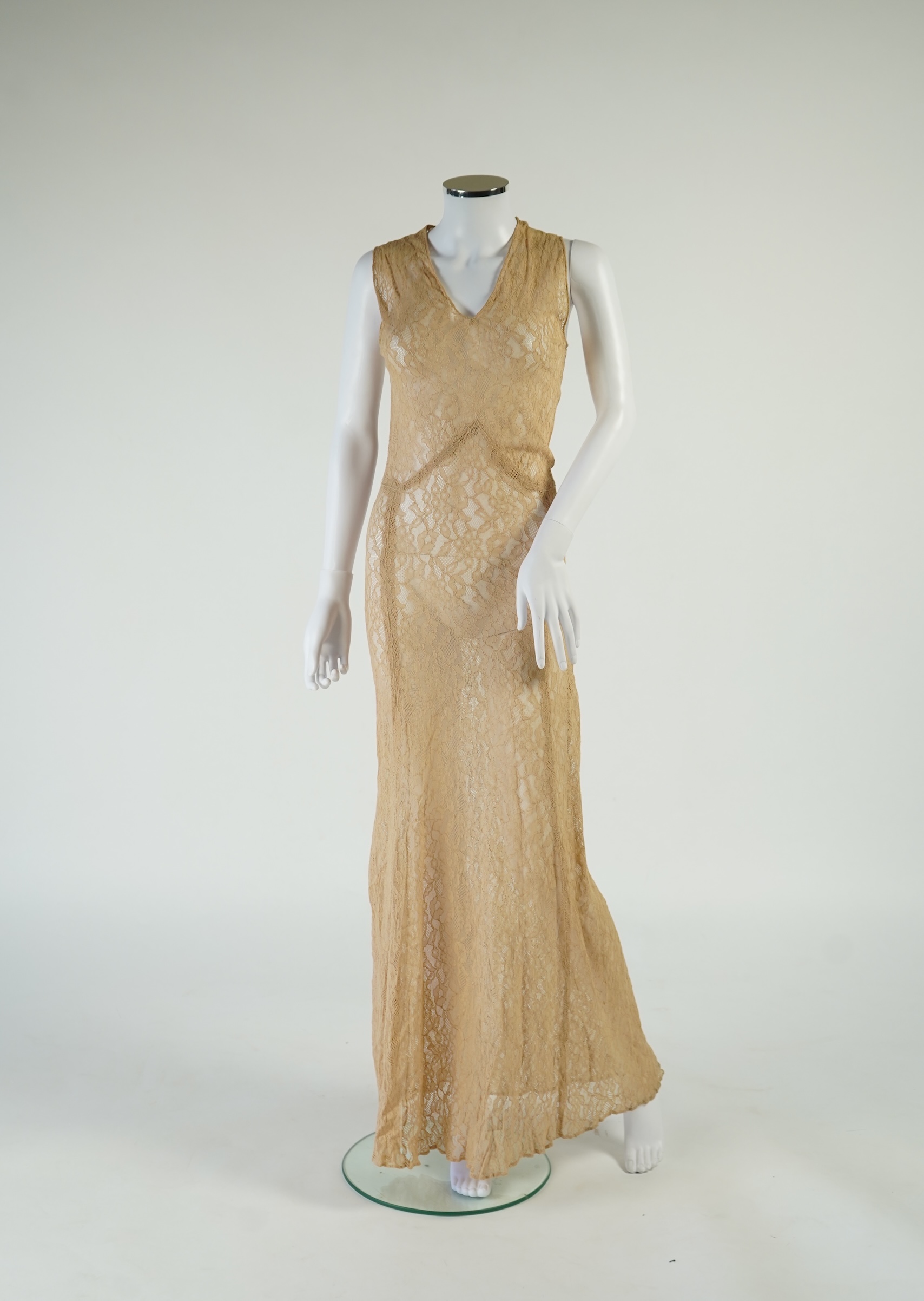 A flesh coloured 1930s lace evening dress and matching jacket together with a bottle green velvet evening dress and buckle belt and an unusual green shot silk pleated under skirt. Lace dress bust 32 inches. 156cm long. C